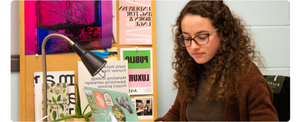 A students works on assignments at her studio desk.